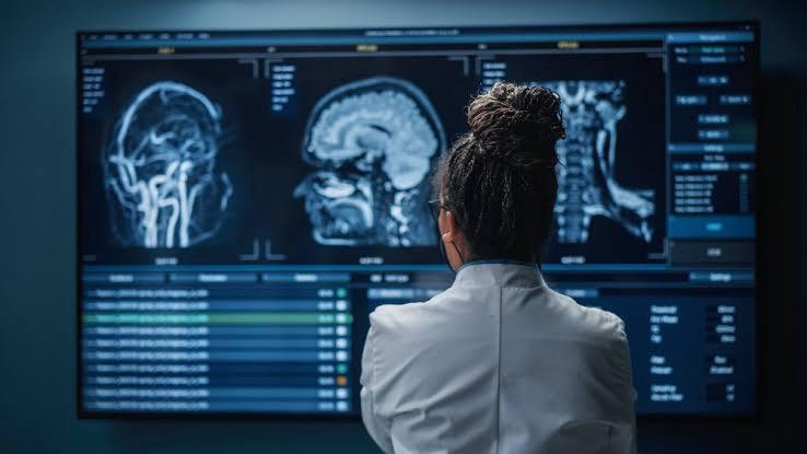 A radiologist reviewing MRI imaging on a diagnostic monitor